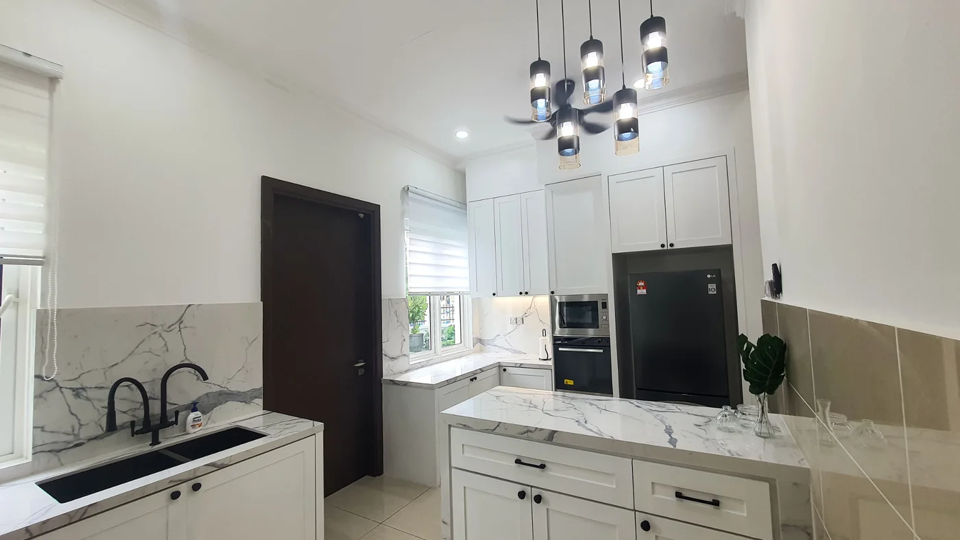 Kitchen with marble countertops and island at the TTDI Heights bungalow