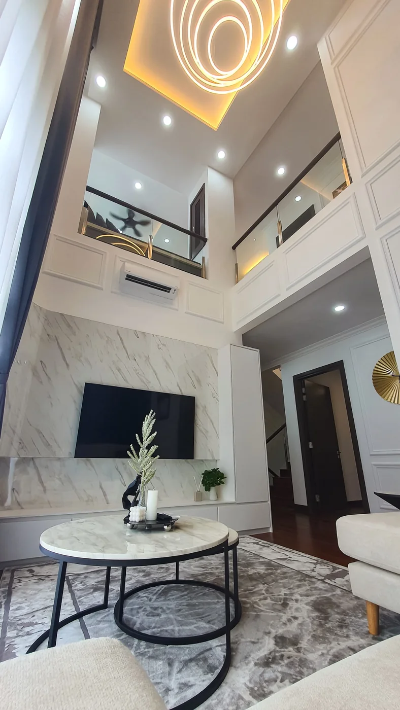 Double-height living room with glass-railed mezzanine at TTDI Heights